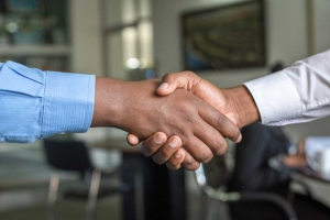 Two individuals shaking hands after registering for MBE Certification with FCC