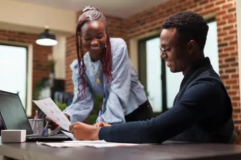 Man and woman looking over paperwork for an economically disadvantaged Minority-owned business.